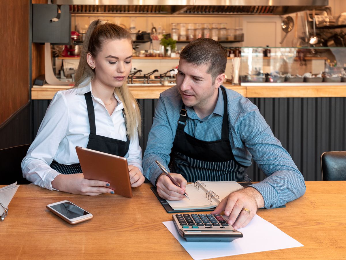 Two small-business owners reviewing their numbers together on a tablet